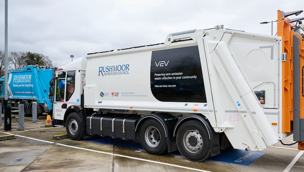 An electric refuse collection vehicle with VEV, Serco and Rushmoor Borough Council branding on a pilot scheme in Hampshire